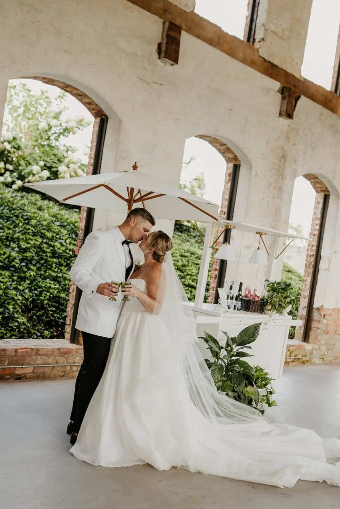Bride and Groom Toast at Speciality Champagne Cart at wedding at Providence Cotton Mill in Maiden, NC