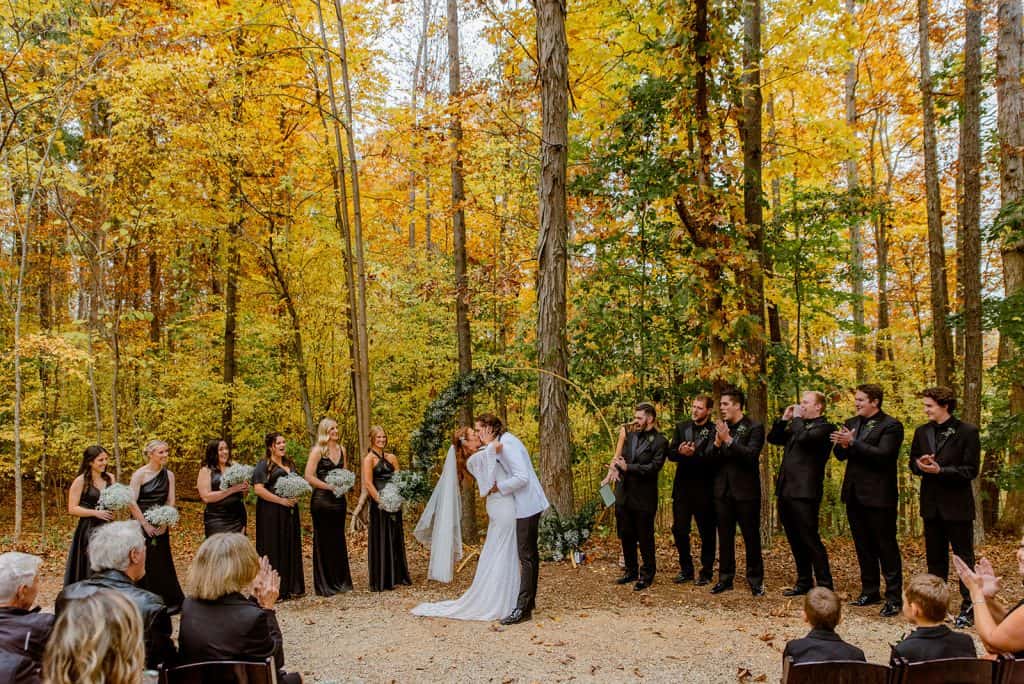 @nicklevinephoto_Abbey-Andrew-Preview_Splendor-Pond_ Woodland Ceremony with Bride and Groom Kissing at Altar_Fall Wedding_ Mooresville Wedding Venue