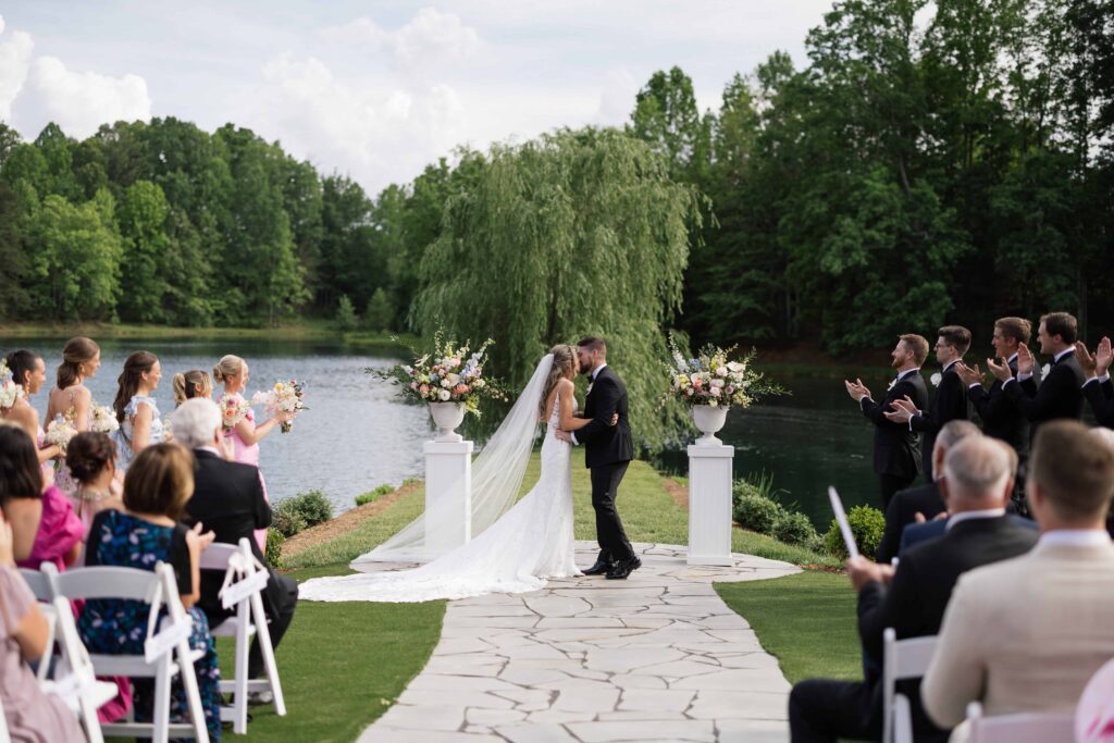 GoldenbrookPhotography-KarinaandMax_Splendor-Pond_Willow Tree Ceremony with Bride and Groom Kissing at Altar at Mooresville Wedding Venue