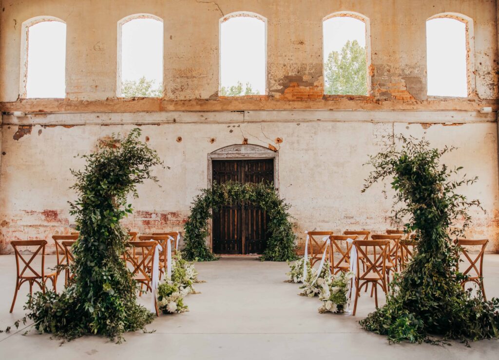 Green and White Southern Luxury Wedding Ceremony with arches and aisle floral clouds at Providence Cotton Mill by Crafted Charm