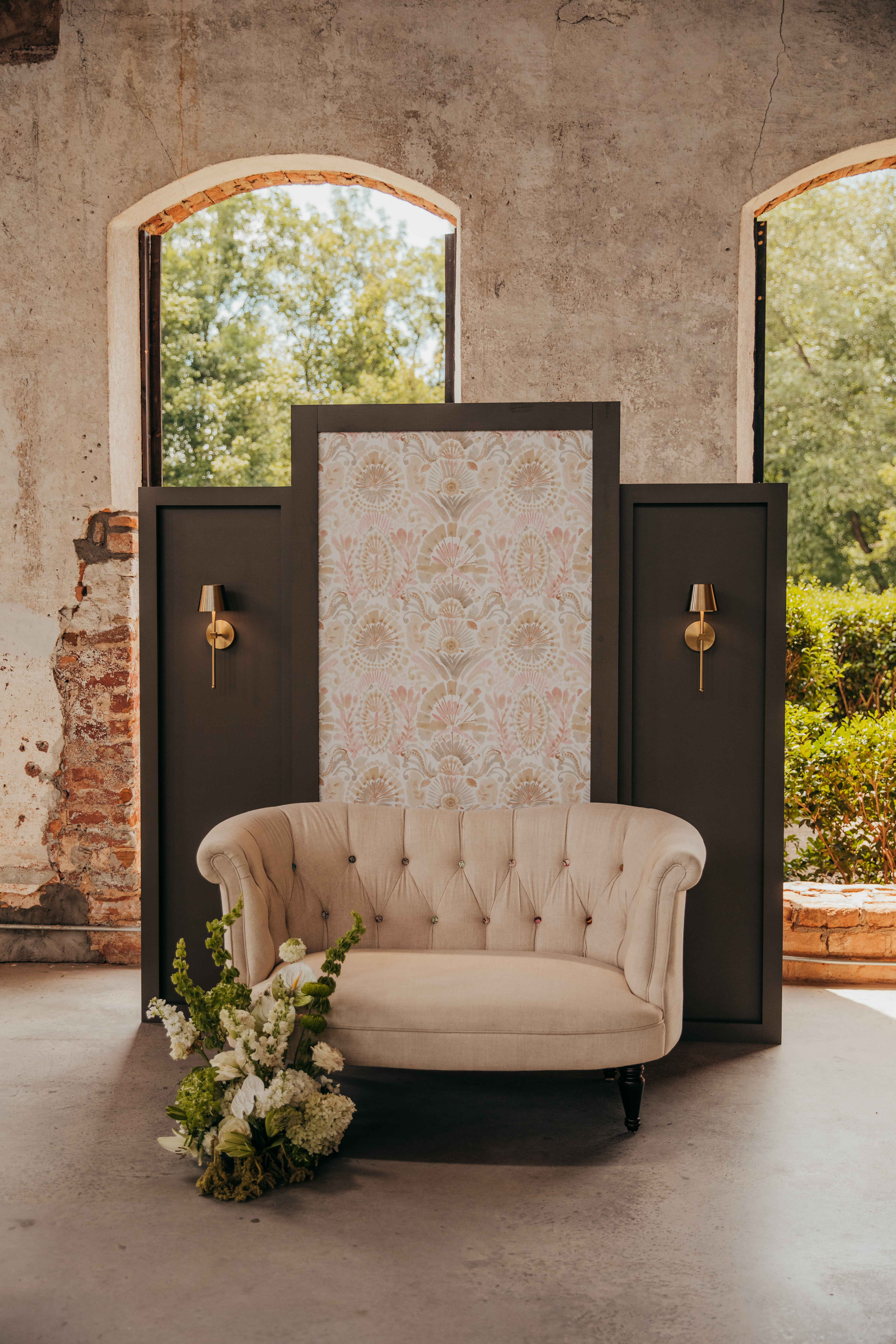 Photo backdrop installation station with colored wallpaper and vintage sofa at Providence Cotton Mill in Maiden, NC