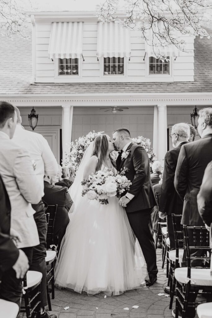bride and groom kissing at altar outside the Morehead inn in Charlotte nc at a luxury estate wedding