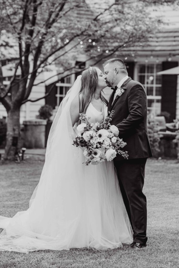 bride and groom portrait, kissing outside the Morehead inn in Charlotte nc at a luxury estate wedding