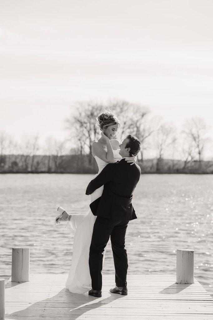 Sunset Ridge Estate luxury southern wedding venue in Monroe NC with bride and groom walking outside of large estate at lakeside property at lake dock for newlywed portraits