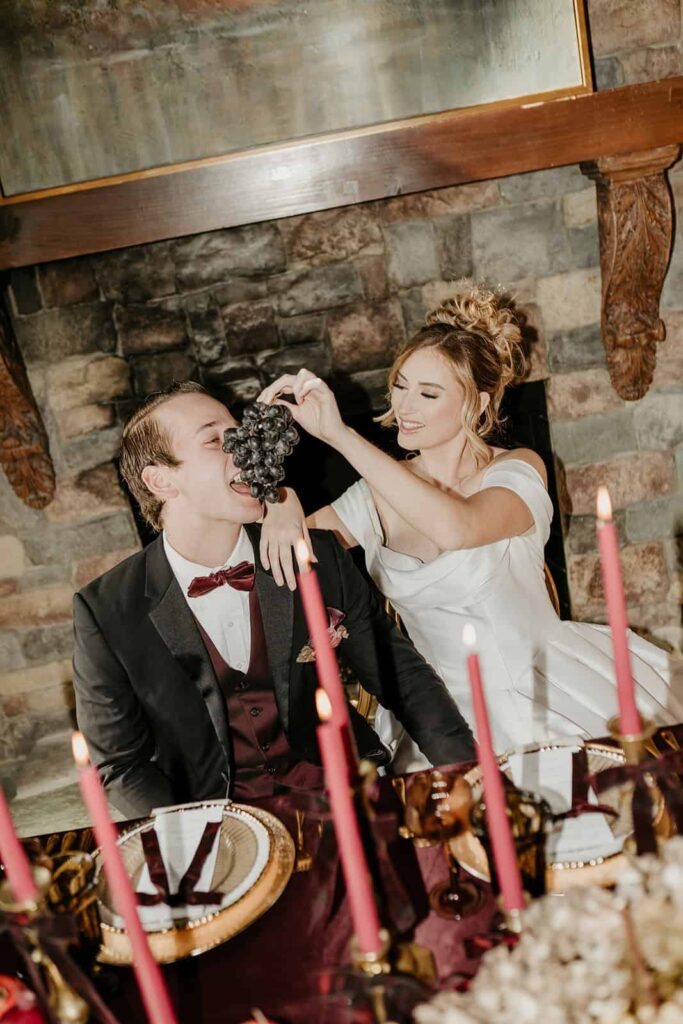 Sunset Ridge Estate luxury southern wedding venue in Monroe NC with bride and groom toasting at moody winter sweetheart table in front of fireplace at large estate for newlywed portraits