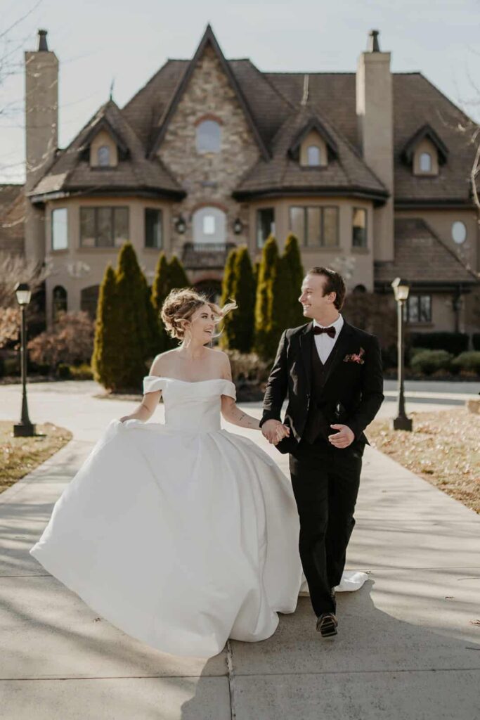 Sunset Ridge Estate luxury southern wedding venue in Monroe NC with bride and groom walking outside of large estate for newlywed portraits