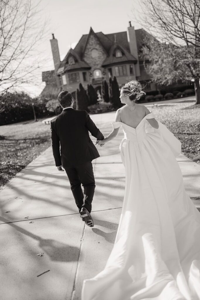 Sunset Ridge Estate luxury southern wedding venue in Monroe NC with bride and groom walking outside of large estate for newlywed portraits