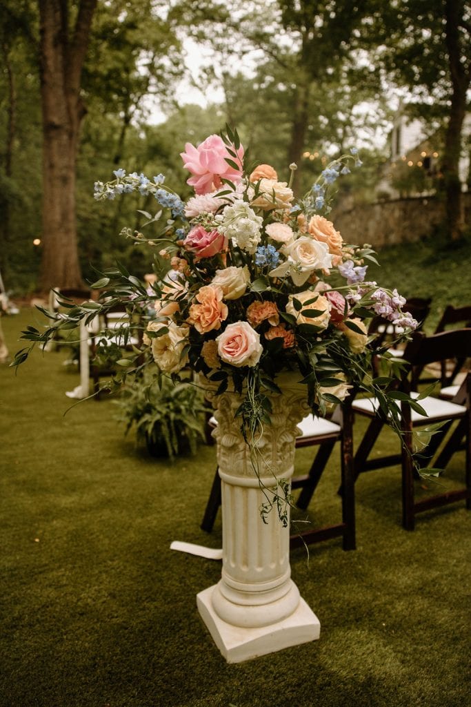 ceremony large floral arrangement on a pedestal column with spring colors and peonies at the Historic Robertson Homestead in Rock Hill, SC
