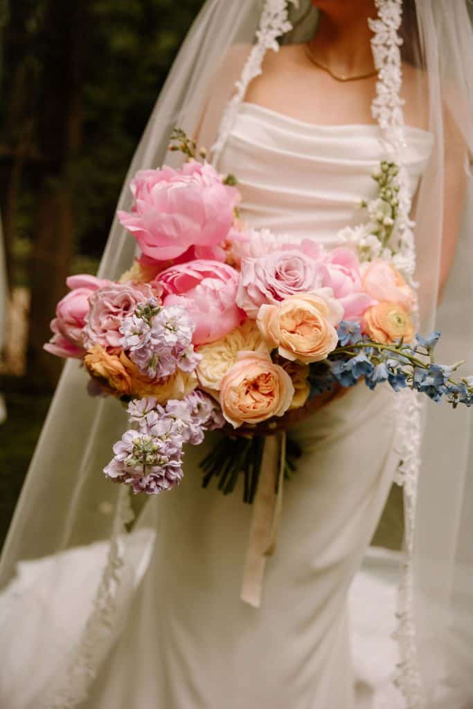 bride portrait carrying large floral bouquet of spring colors and peonies at the Historic Robertson Homestead in Rock Hill, SC