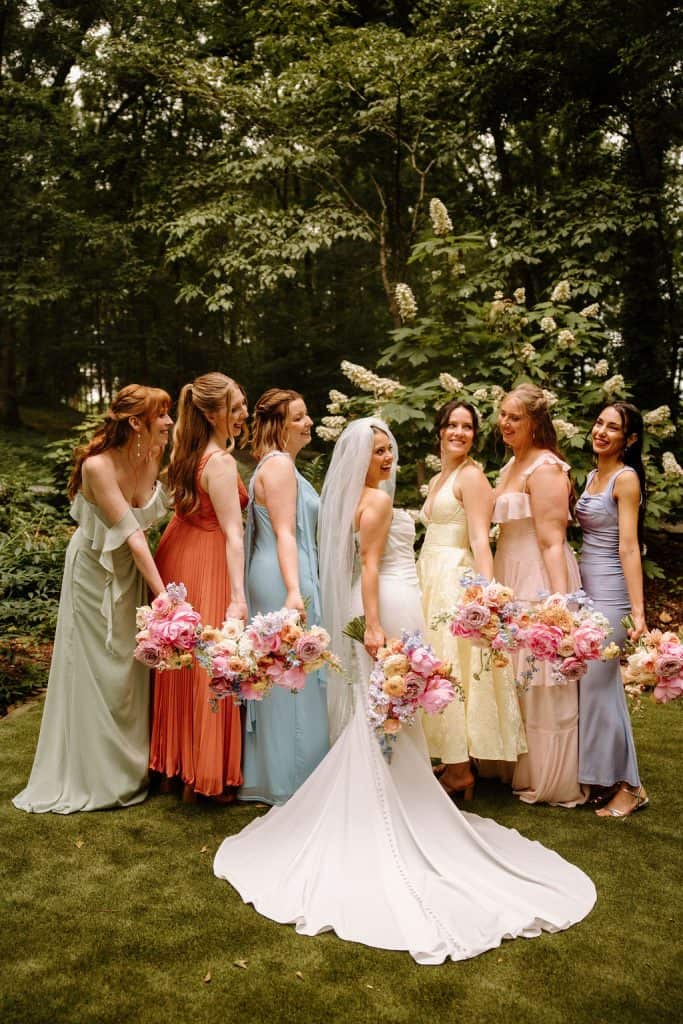 bride and bridesmaid portrait carrying large floral bouquet of spring colors and peonies at the Historic Robertson Homestead in Rock Hill, SC