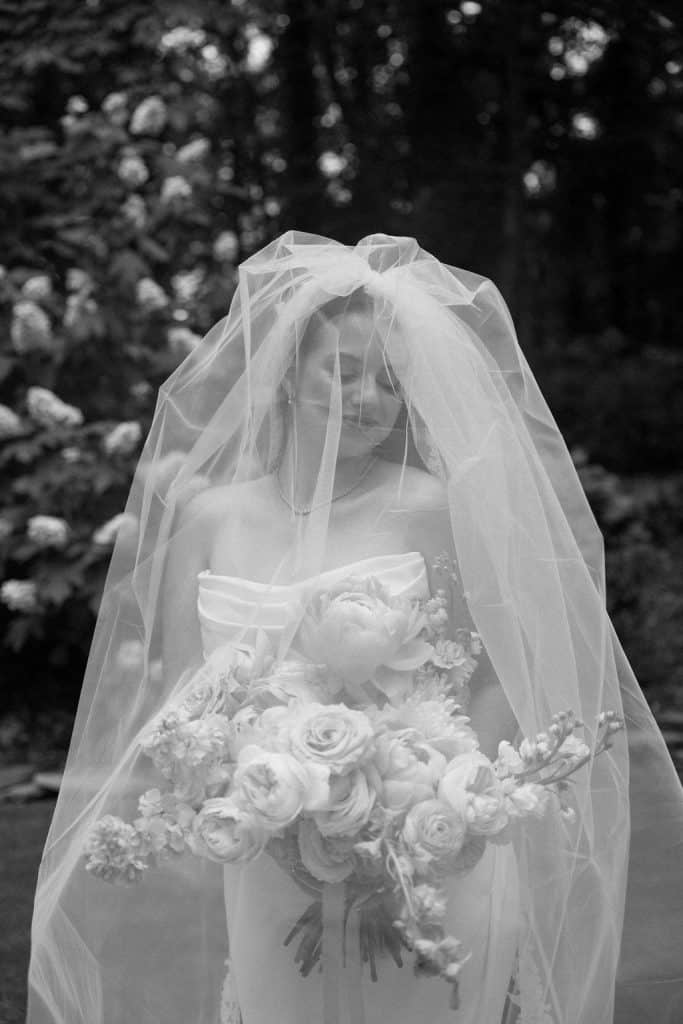bride portrait with bride carrying large floral bouquet of spring colors and peonies at the Historic Robertson Homestead in Rock Hill, SC