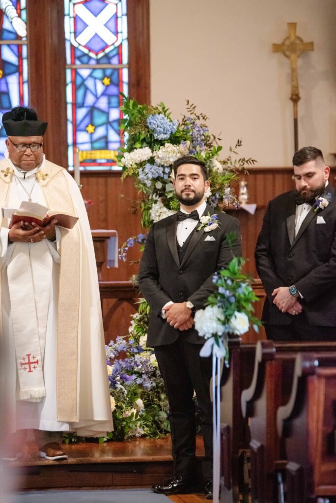 Groom at ceremony chapel at The Rafters at Historic St. Mark in Huntersville, NC at a classic blue and white styled wedding.