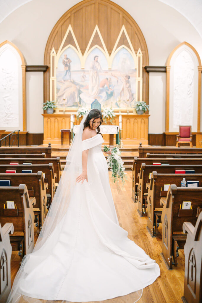 bride posing in St. Peters Catholic Church in Charlotte NC following a ceremony