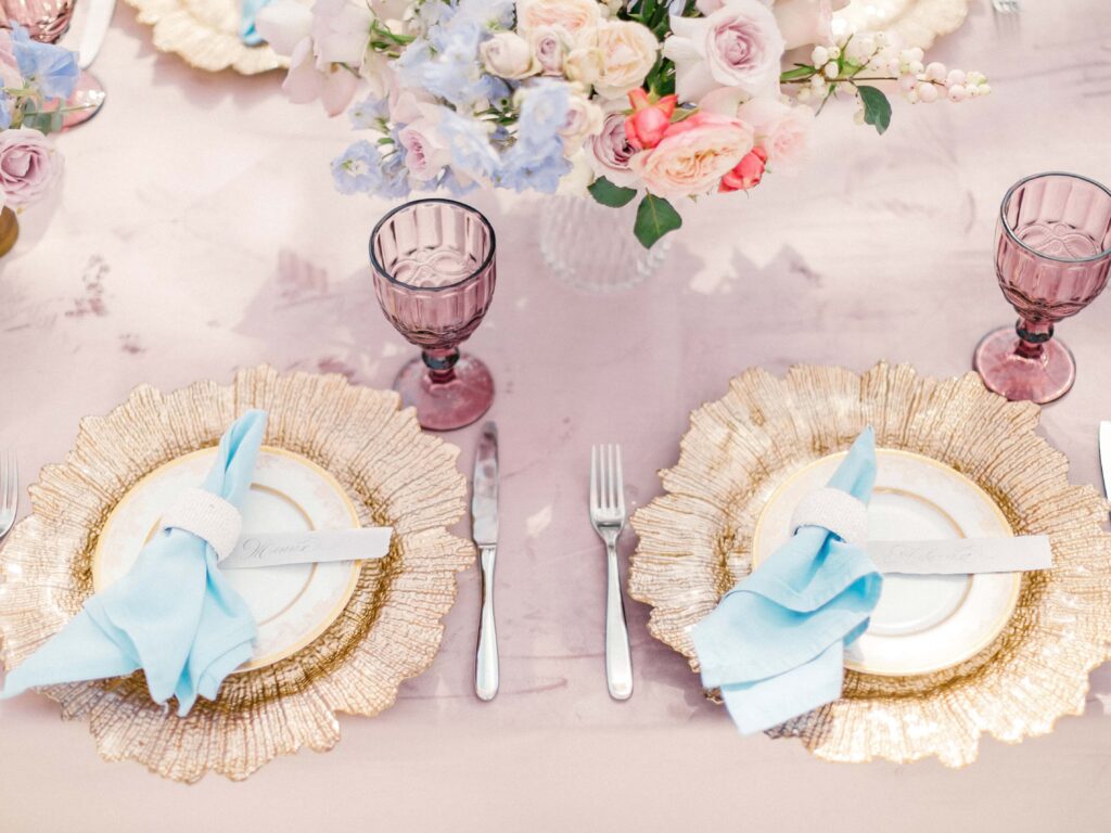 place setting at wedding with pink glasses and gold chargers