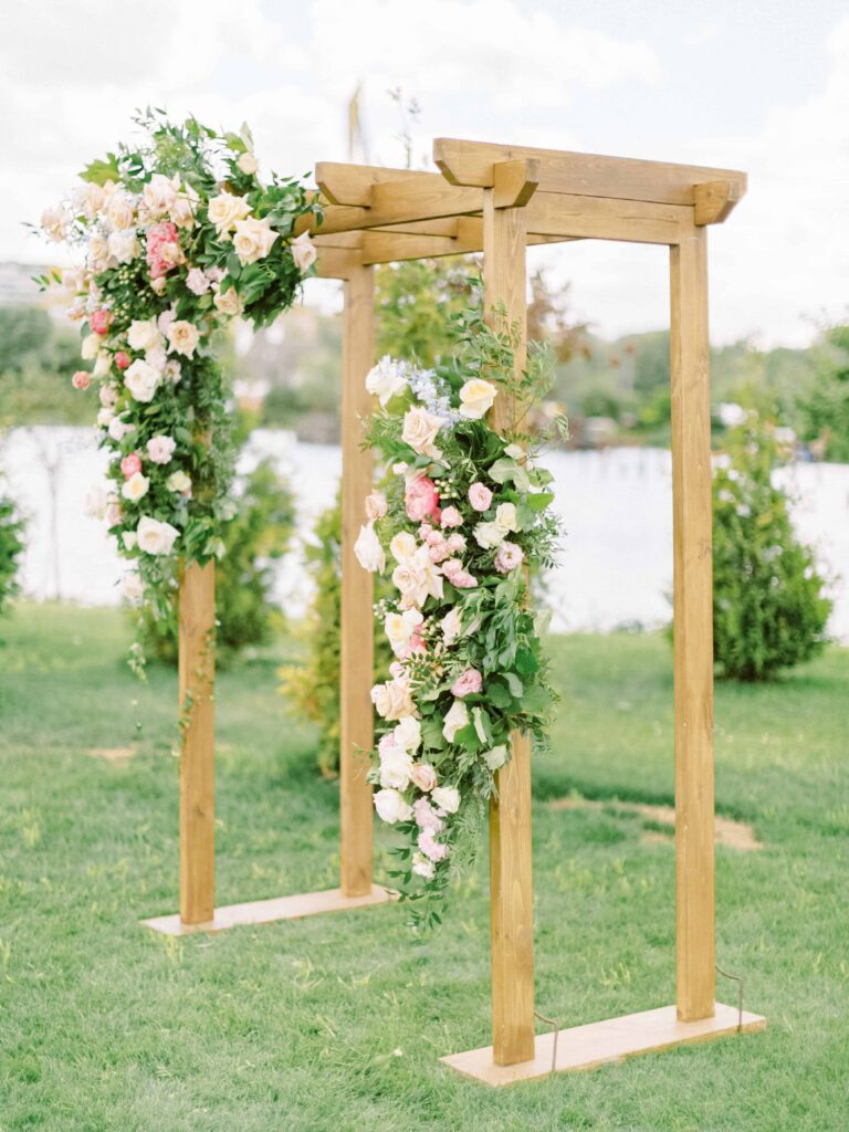 floral arch swag installation for a wedding ceremony in soft neutrals and pinks