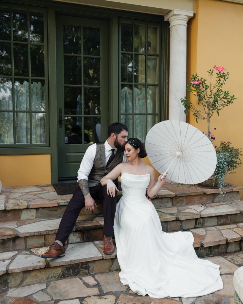 Le Chateau Du Coeur Wedding- bride and groom portrait sharing kiss outside stone steps