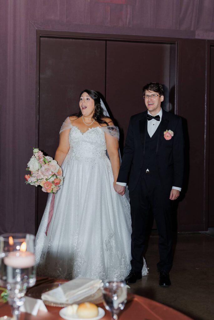 Bride and groom reception reveal at The Revelry Charlotte NC wedding venue decorated in luxury florals with gold and soft pink accents by Crafted Charm Florals