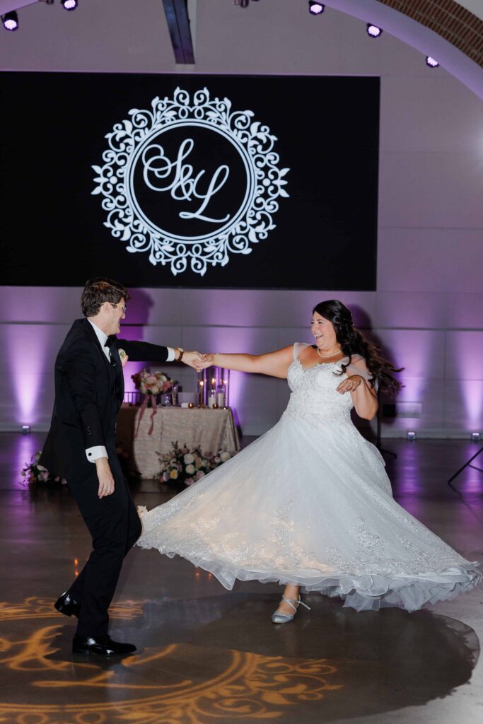 Bride and groom dancing at The Revelry Charlotte NC wedding venue decorated in luxury florals with gold and soft pink accents by Crafted Charm Florals